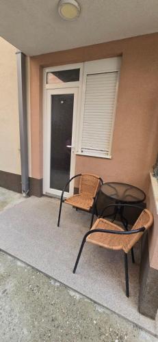 a patio with two chairs and a table and a window at Apartaman Ana 5 in Kravlja