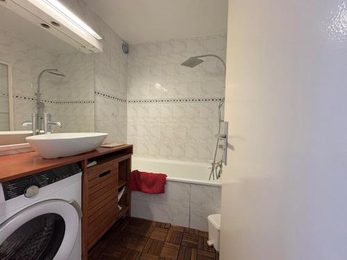 une salle de bain avec une machine à laver et un lavabo dans l'établissement Appartement - Cap d'Agde, au Cap d'Agde