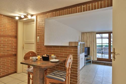 a kitchen with a table and a brick wall at Fischerhaus Whg Abendrot in Neukloster