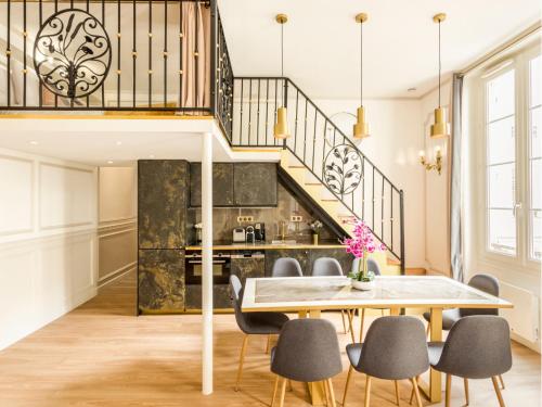 une salle à manger avec une table et des chaises et un escalier dans l'établissement Merveil - Luxury Suite -ChampsElysees- Florentin I, à Paris