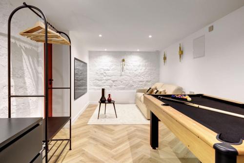 un salon avec une table de billard et un canapé dans l'établissement Duplex de Luxe avec billard et baignoire, à Paris
