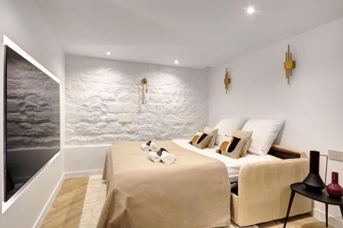 deux lits dans une chambre aux murs blancs dans l'établissement Duplex de Luxe avec billard et baignoire, à Paris