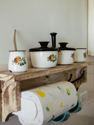 a group of pots and pans on a wooden shelf at Dolce Casa Departamentos in Neuquén