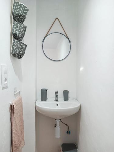 a white bathroom with a sink and a mirror at Casa Robles, casa con piscina y barbacoa in Partida de La Cañada