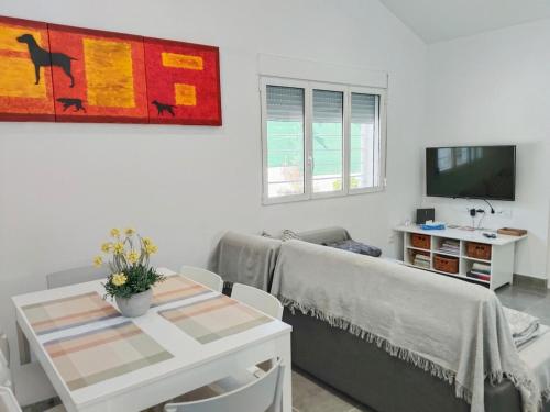 ein Wohnzimmer mit Sofa und Tisch in der Unterkunft Casa Robles, casa con piscina y barbacoa in Partida de La Cañada