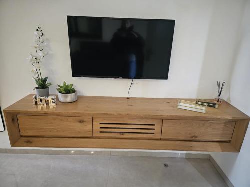 a wooden entertainment center with a television on a wall at הנופש הצפוני in Qiryat Shemona