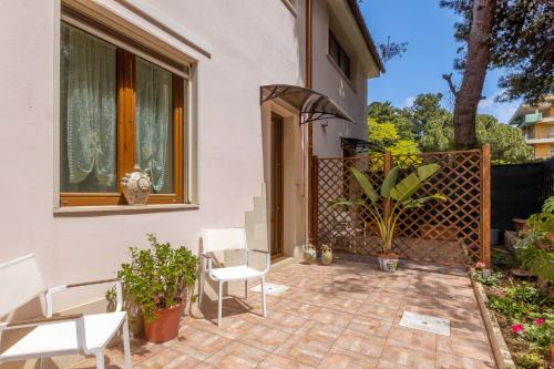 a patio with white chairs and a fence at Hotel Parco delle Fontane in Siracusa