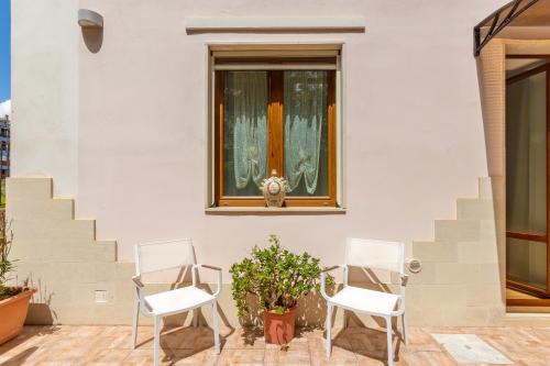 two chairs sitting on a patio with a window at Hotel Parco delle Fontane in Siracusa