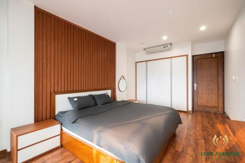 a bedroom with a large bed and wooden floors at Luxe Paradise Residence Trinh Cong Son in Hanoi