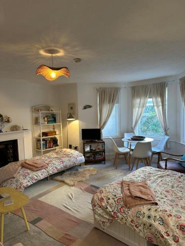 ein Schlafzimmer mit 2 Betten und ein Esszimmer mit einem Tisch in der Unterkunft Home By The Sea in Eastbourne