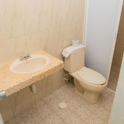 a bathroom with a toilet and a sink at Hotel Las Palmas en Laurel in Cancún