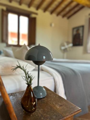a lamp on a table next to a bed at Boutique Bio Agriturismo Casale San Cristoforo in Città di Castello