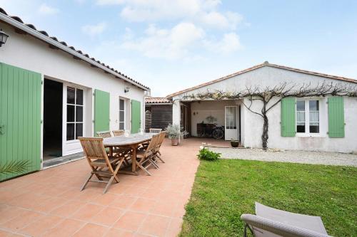 un patio avec une table et des chaises dans une cour dans l'établissement 503 L'Îlot Between Land and Marsh, à Loix