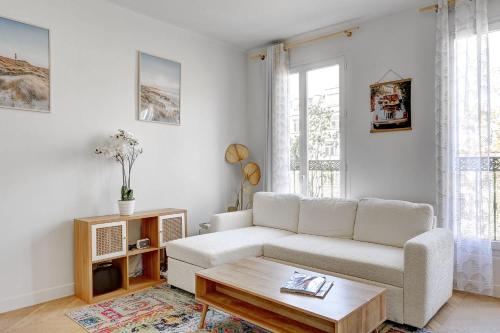 un salon avec un canapé blanc et une table basse dans l'établissement Flat de luxe a Republique avec terrasse, à Paris