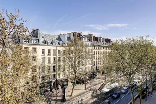 un grand bâtiment blanc avec une rue en face dans l'établissement Flat de luxe a Republique avec terrasse, à Paris