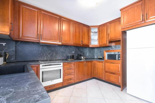 a kitchen with wooden cabinets and a white refrigerator at Nasia House Paliouri in Paliouri