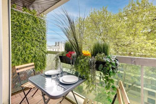 d'une table et de chaises sur un balcon orné de plantes. dans l'établissement BM-2Person cosy avec terrasse, à Paris