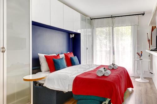 - une chambre dotée d'un grand lit avec des oreillers rouges et bleus dans l'établissement BM-2Person cosy avec terrasse, à Paris