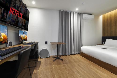 a hotel room with a bed and a desk with a computer at Justsleep hotel Cheonan Dujeong branch in Cheonan