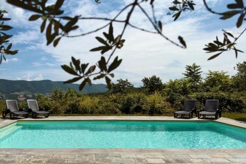 a pool with chairs and a view of the mountains at Castello di Cisterna in Cisterna