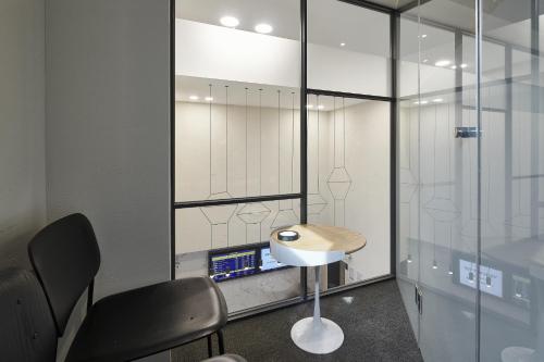 a room with a desk and two chairs and a glass wall at Justsleep hotel Cheonan Dujeong branch in Cheonan