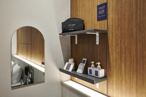 a bathroom with two shelves and a mirror at Justsleep hotel Cheonan Dujeong branch in Cheonan
