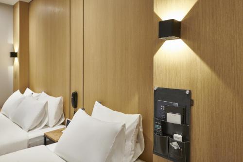 a hotel room with two beds and a light on the wall at Justsleep hotel Cheonan Dujeong branch in Cheonan