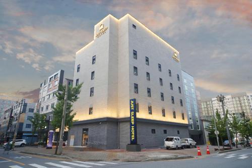 a large white building on the corner of a street at Justsleep hotel Cheonan Dujeong branch in Cheonan
