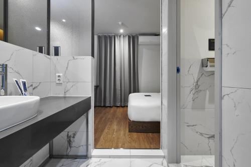 a white bathroom with a sink and a shower at Justsleep hotel Cheonan Dujeong branch in Cheonan