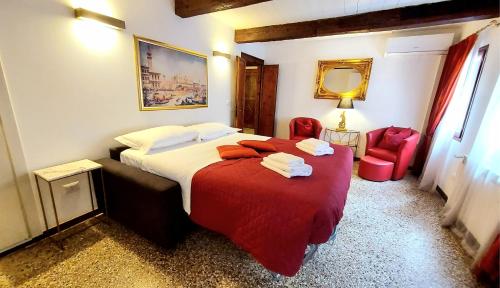 a hotel room with a bed with a red blanket at Palazzo del Sale, Rialto in Venice