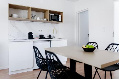 a white kitchen with a table and chairs at Villa Oliver Lenti in Lenti
