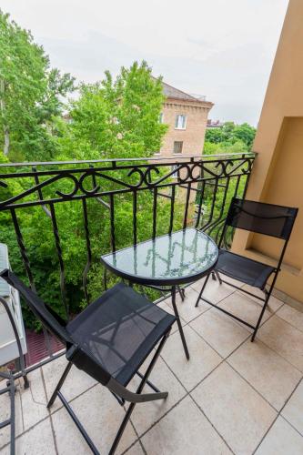 a balcony with a glass table and chairs on it at Secret Apartments in Kyiv