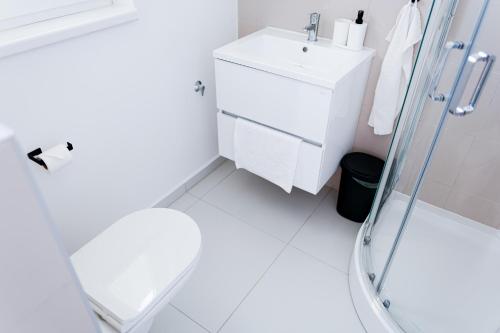 a white bathroom with a sink and a shower at Villa Oliver Lenti in Lenti
