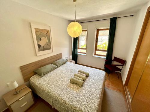 a bedroom with a bed with a chair and a lamp at Apartment Font Rotja Albir in Albir