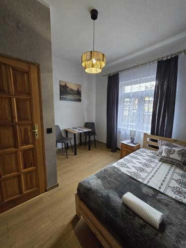 a bedroom with a bed and a table and a window at Kowali Wierch - blisko Centrum i Dworca PKP in Zakopane