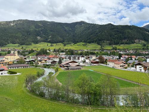 a small town in the mountains with a river at Auszeit im Holzhaus in Steinach am Brenner