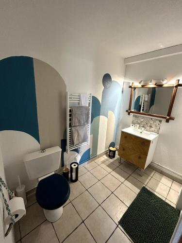une salle de bain avec un lavabo, des toilettes et un miroir dans l'établissement Jolie T2 avec terrasse proche plage, à Soulac-sur-Mer