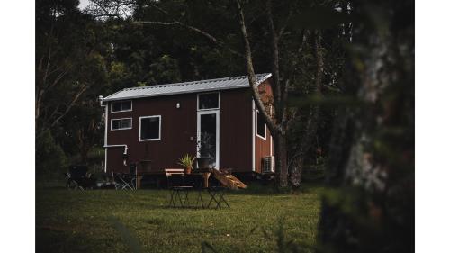a red tiny house sitting in a yard at Tiny Inja 1 by Tiny Away in Comleroy