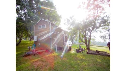 a house in a grassy field next to a house at Tiny Inja 1 by Tiny Away in Comleroy