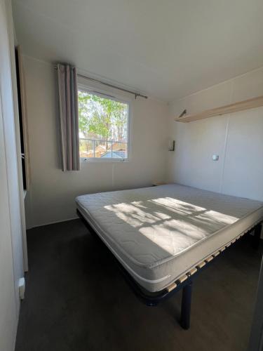 une chambre avec un lit dans une pièce avec une fenêtre dans l'établissement F033 - Bungalow 6 personnes 3 chambres, à Boofzheim
