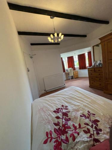a bedroom with a white bed with a flower pattern on it at Stanley in Wallington