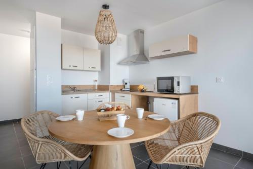 - une cuisine avec une table et des chaises en bois dans l'établissement Bel appartement pour 4 face mer, à Pléneuf-Val-André