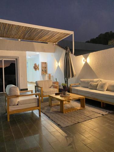a living room with couches and a table at Lomas del Encanto, villa en la montaña cerca del mar in La Asunción