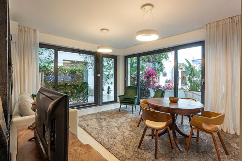 a living room with a tv and a table and chairs at 54 São Paulo - Exclusive Apartment Hotel in Lisbon