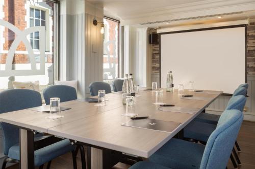 a conference room with a large table and blue chairs at Hilton York in York