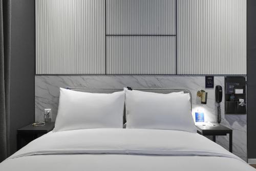 a bed with white sheets and pillows in a bedroom at Justsleep hotel Cheonan Dujeong branch in Cheonan