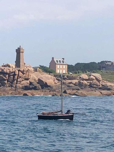 a small boat floating in the water near a island at Lieu paisible et indépendant in Bégard