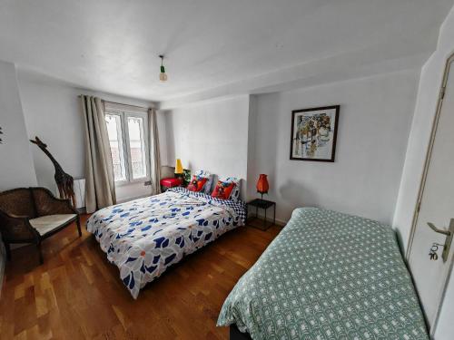 une chambre avec deux lits et une chaise dans l'établissement Grand loft bourgeois, Coeur Vieux Lyon, à Lyon