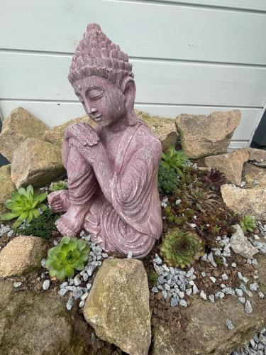 a statue of a woman sitting on a pile of rocks at Lieu paisible et indépendant in Bégard
