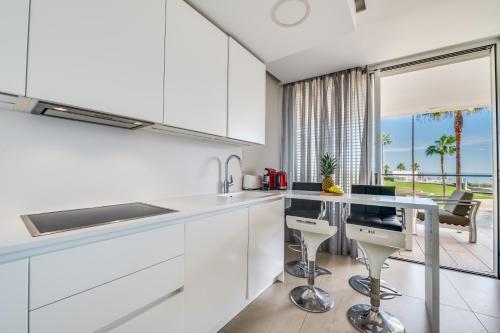 a white kitchen with a view of the ocean at Edge Beachfront 2BR - 3 pools, 1 heated, spa, gym, cowork in Estepona